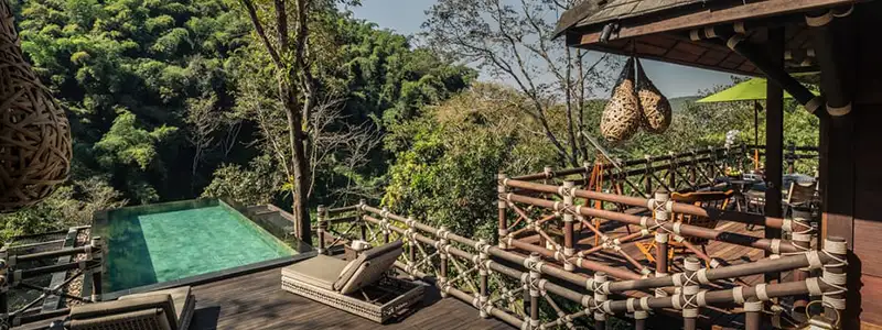 A couple looks out over Thailand's jungles at Four Seasons Tented Camp Golden Triagle