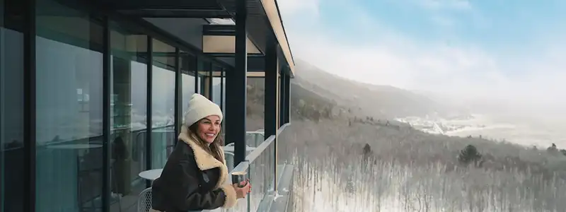 A woman looks out over the winter mountain scenery at Club Med Charlevoix