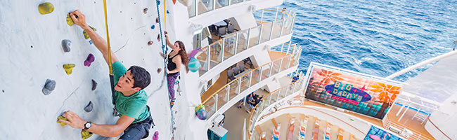 Teenager climbing rock wall on a cruise ship
