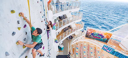 Two teens on the climbing wall of a cruise ship