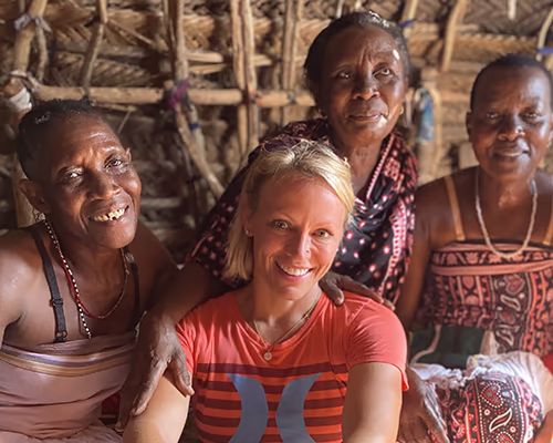 An American woman has a meaningful moment with Maasai women during a village visit on an authentic village visit.