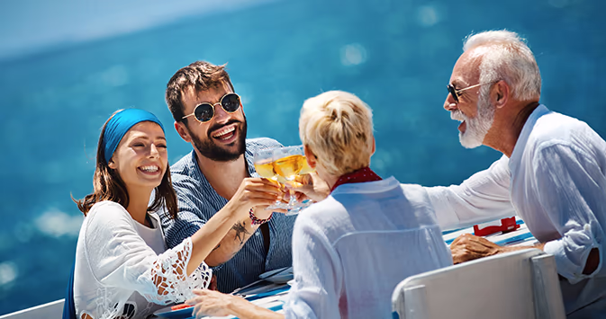 Multigenerational family traveling together toasts champagne on a luxury cruise