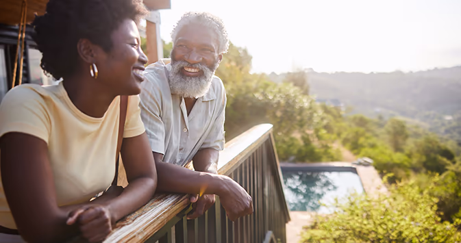 Older black couple on the porch of a luxury villa