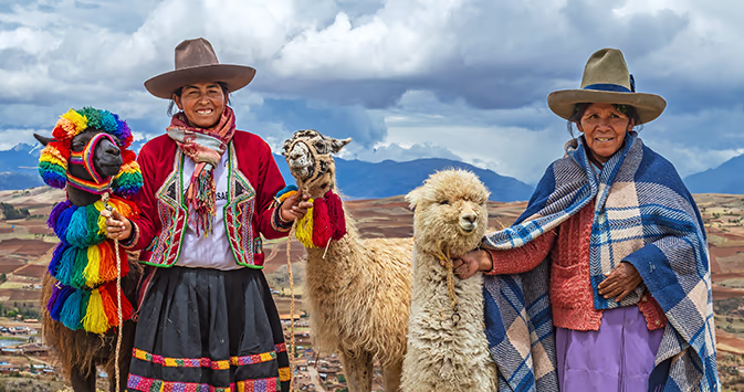 Two local Peruvian women with llamas - cultural travel experiences