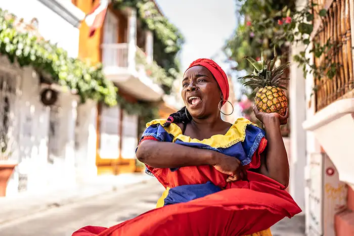 Palenquera walking and dancing on the street in Cartagena, Colombia