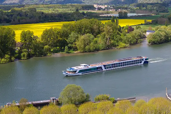 An AmaWaterways river  ship glides along a river