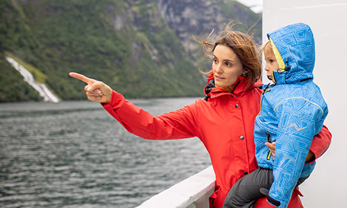 A mother points out nature from the deck of a cruise ship