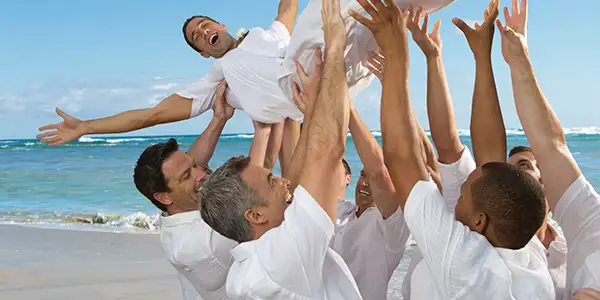 A group of friends lifting a groom into the air